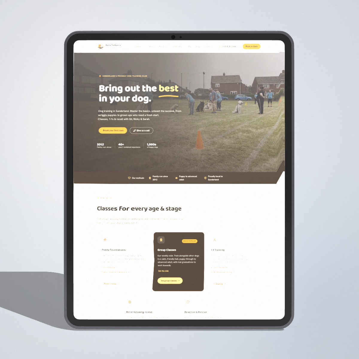 A 3D iPad Pro mockup facing straight forward on a pale grey backdrop, showing the Back To Basics dog training site in portrait.